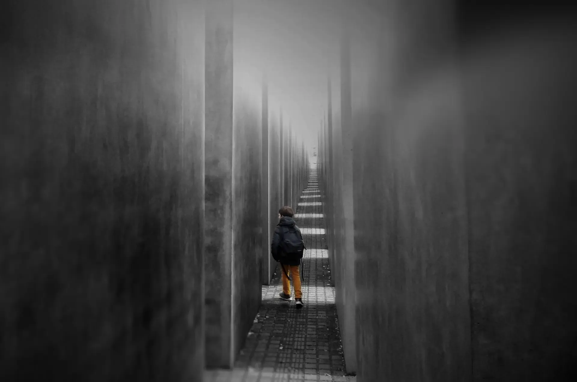 Une perspective d'un monument gris avec un enfant au premier plan.